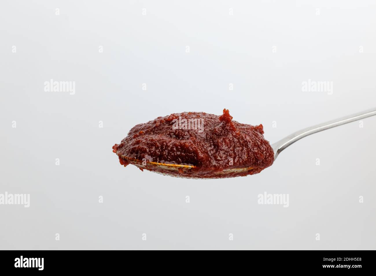 Pasta di pepe rosso e piccante su fondo bianco Foto Stock