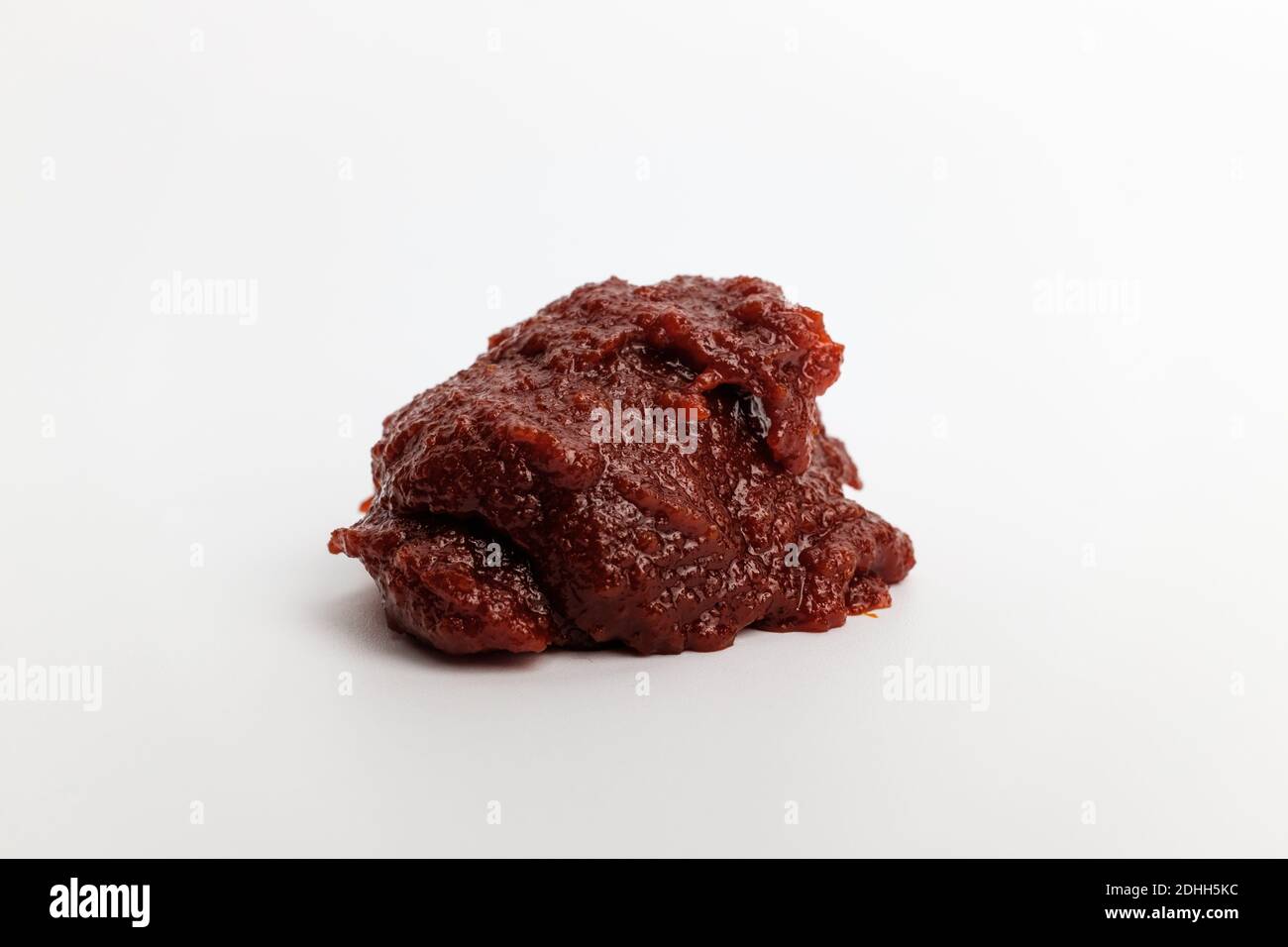 Pasta di pepe rosso e piccante su fondo bianco Foto Stock