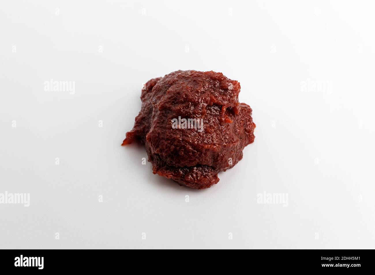 Pasta di pepe rosso e piccante su fondo bianco Foto Stock