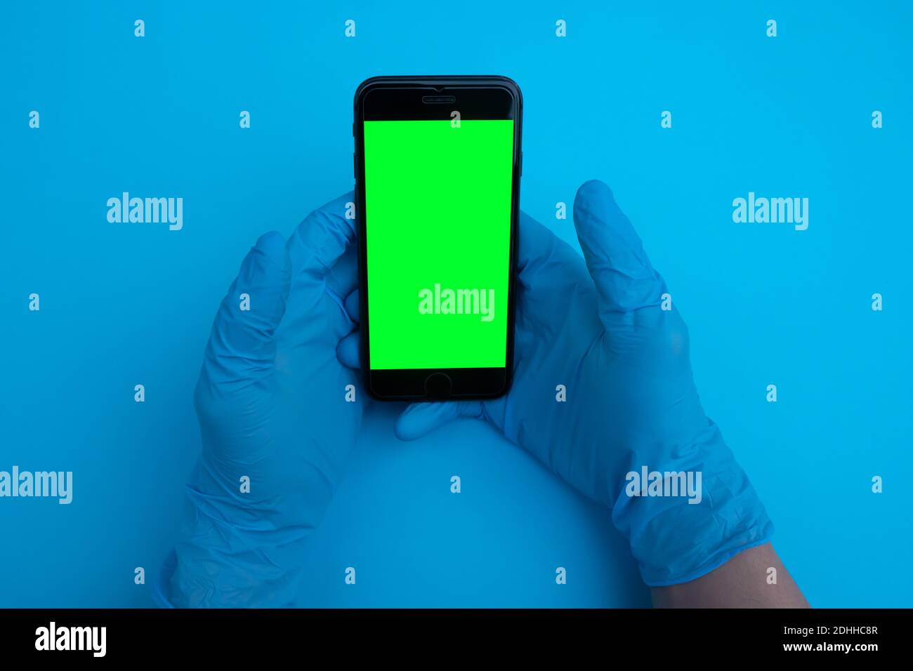 Medico che tiene lo smartphone con schermo verde Foto Stock