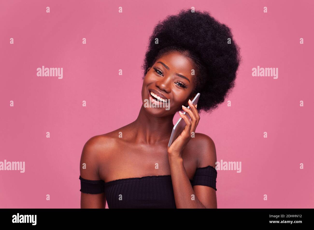 Allegra parlando al telefono African American donna che chiacchiera con le fidanzate utilizzando il suo smartphone. Modello femminile con acconciatura afro in piano taglio nero Foto Stock