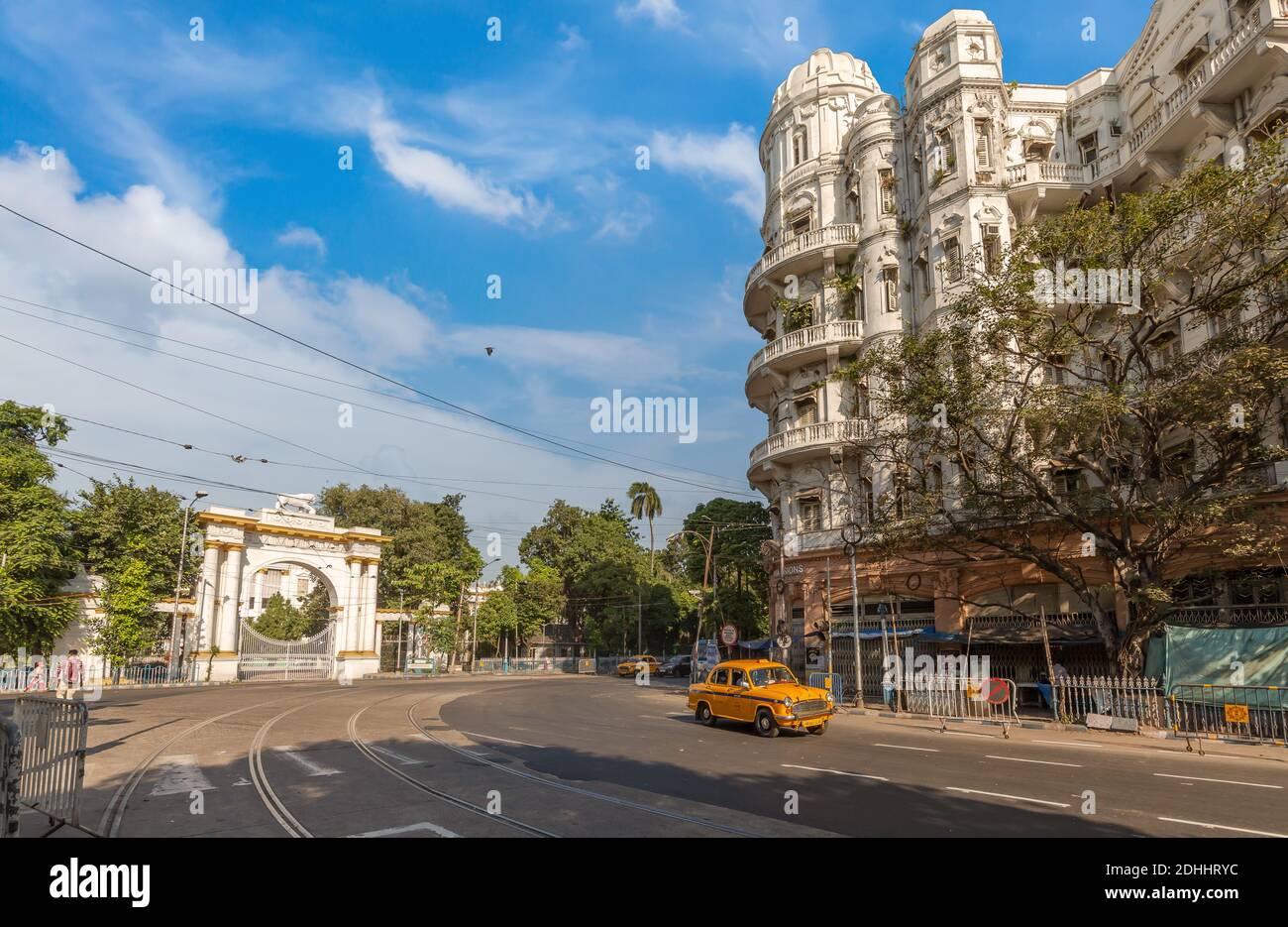 Strada cittadina con taxi giallo vicino all'entrata della casa del Governatore con vista sugli edifici del patrimonio coloniale nell'area di Dalhousie Kolkata, India Foto Stock