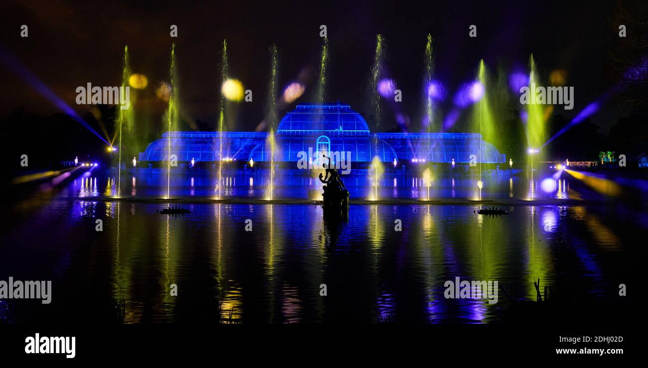 Una vista della 'Palm House Grand finale', che include proiezioni festive che cadono su un enorme schermo d'acqua nel lago durante il Natale a Kew presso i Royal Botanic Gardens a Kew, Londra. Foto Stock