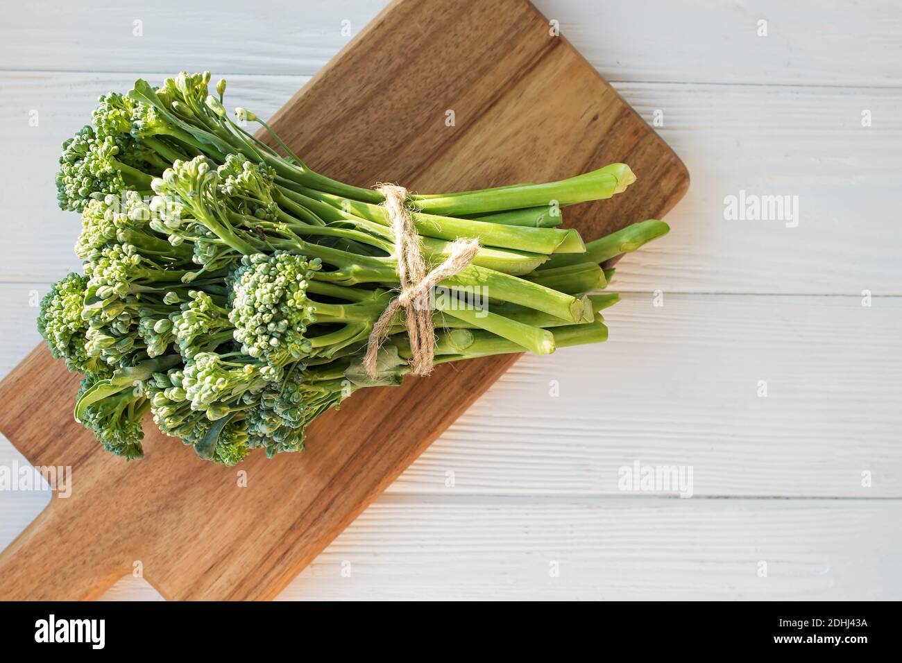 Verdure crude verdi broccolini su tavola di legno. Cibo biologico sano, vista dall'alto Foto Stock