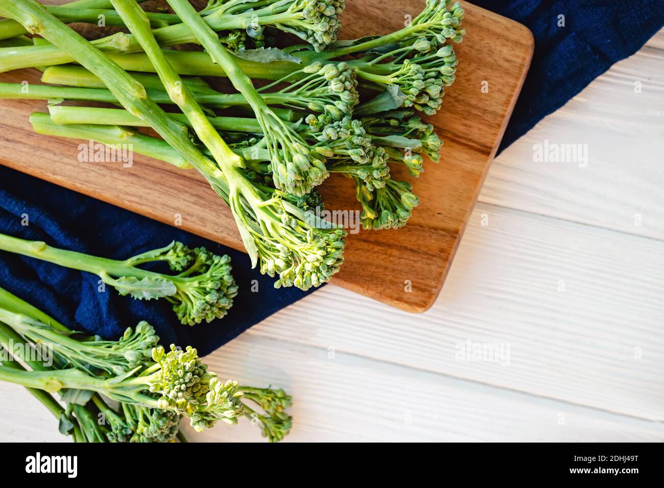 Verdure crude verdi broccolini su tavola di legno. Cibo biologico sano, vista dall'alto Foto Stock