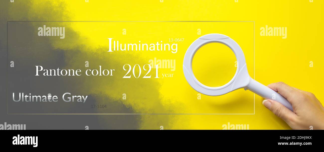 Pantone Color of the Year 2021. Lente di ingrandimento con mano sul giallo. Tendenza colore. Illuminazione. Ultimate Grey Foto Stock