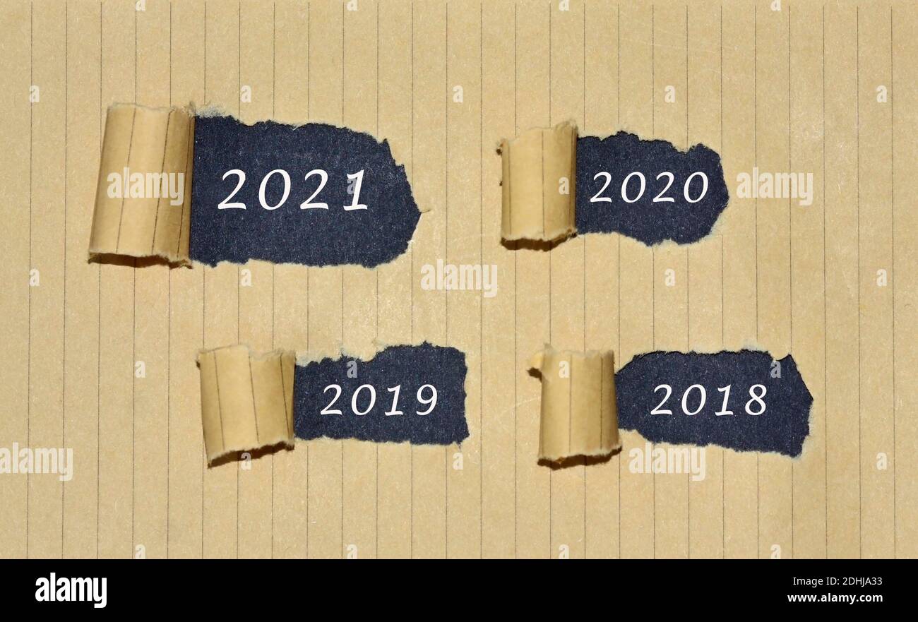 numero 2021, 2020, 2019 e 2018 scritto su carta marrone strappata . Concetto di anno nuovo passato e felice Foto Stock