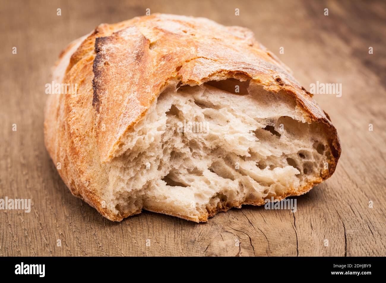 Un pezzo di pane su tavola di legno Foto Stock
