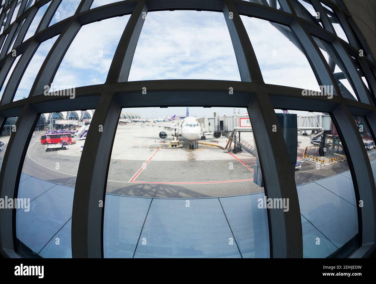 Vista dell'obiettivo fish eye degli aeroplani parcheggiati sulla asfalto dell'aeroporto dalla finestra del terminal. Foto Stock