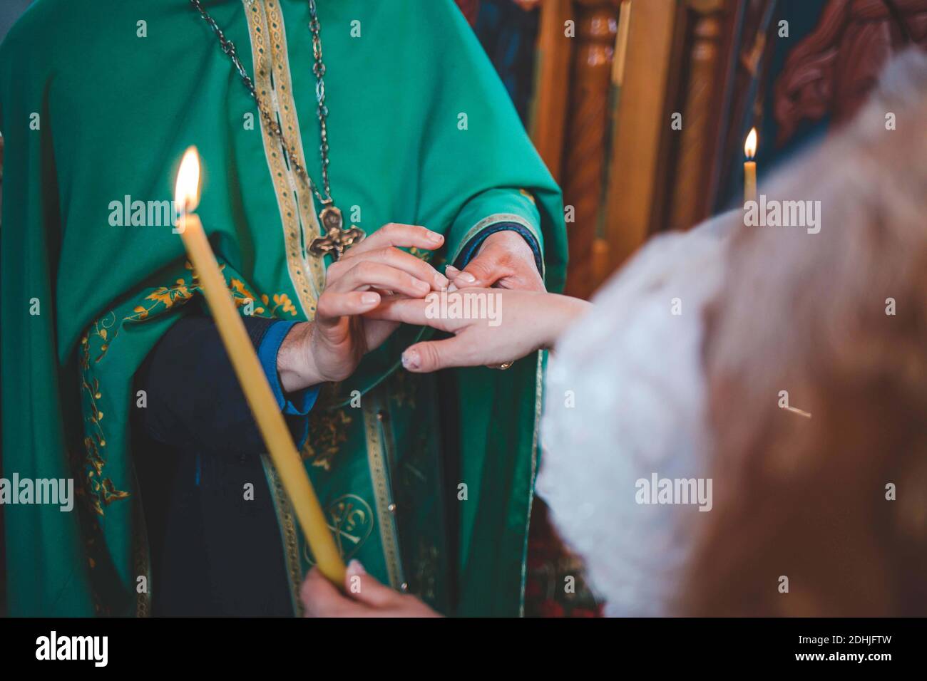 Un closeup del sacerdote che tiene la mano della sposa e. benedicendolo durante una cerimonia matrimoniale Foto Stock