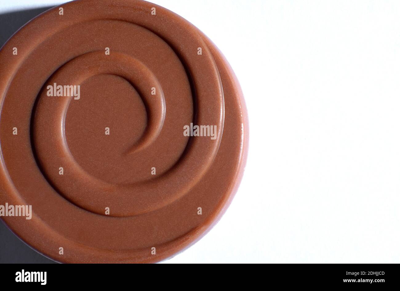 ricco biscotto al cioccolato al latte con decorazione a vortice su sfondo bianco Foto Stock