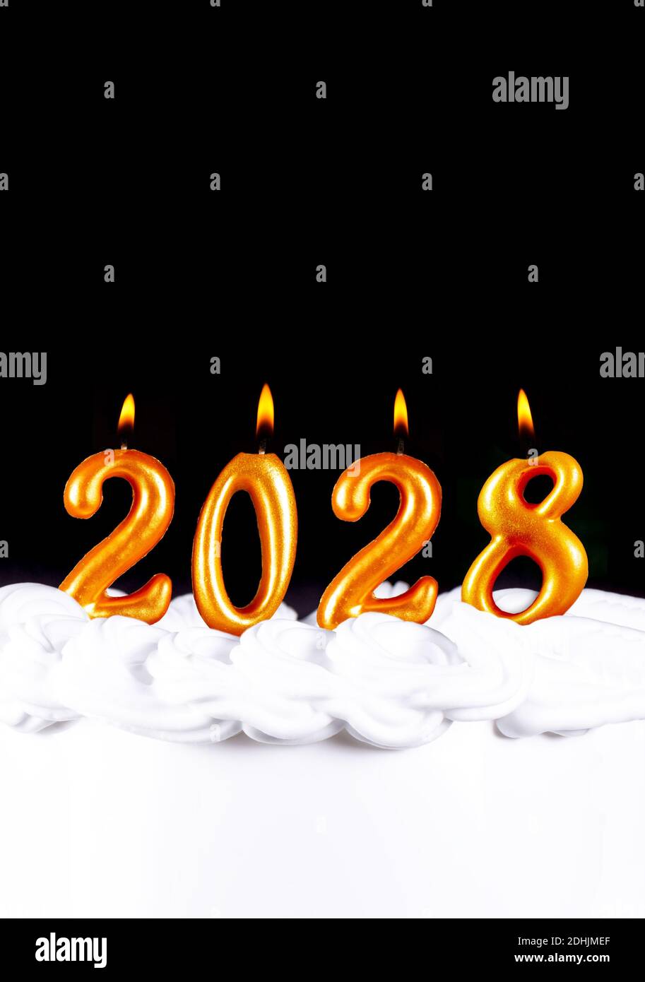 Quattro candele d'oro scrivono numeri fiamma felice anno nuovo 2028 sfondo nero Foto Stock