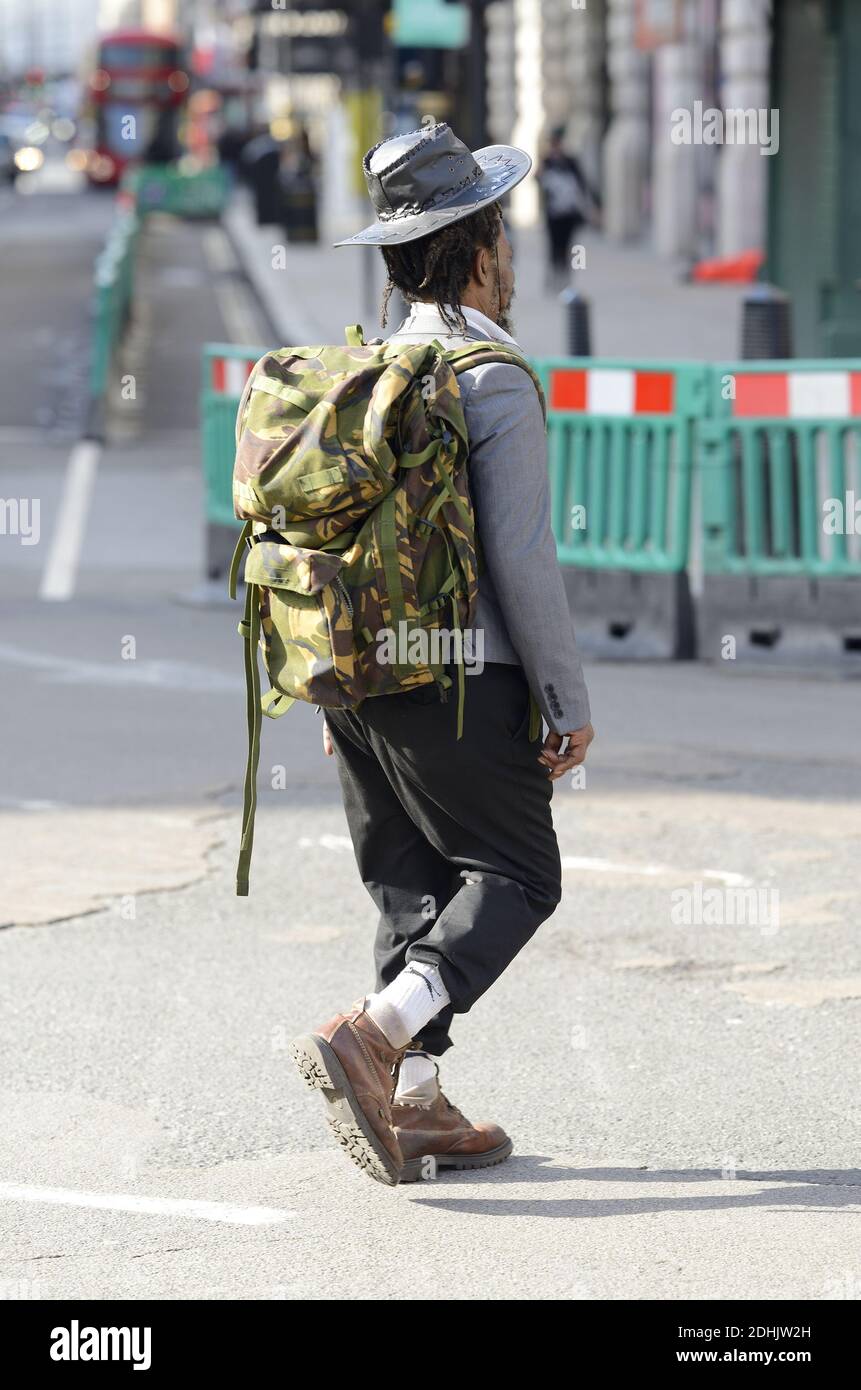 Londra, Inghilterra, Regno Unito. Uomo con dreadlock che indossa uno zaino camouflage e un cappello bush a Piccadilly Circus Foto Stock