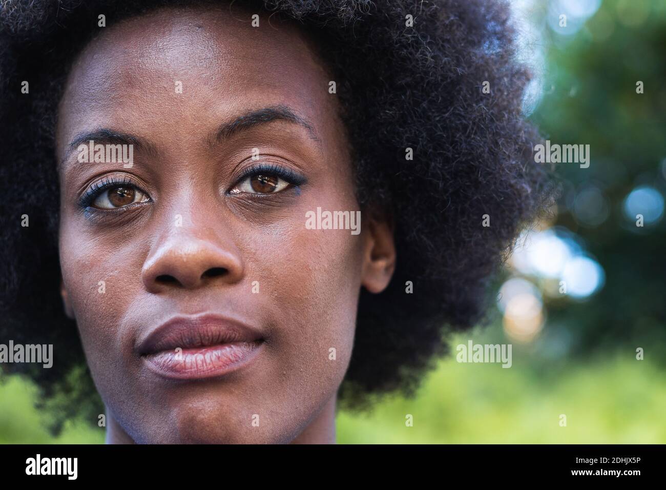 Donna nera con acconciatura Afro che guarda la fotocamera Foto Stock
