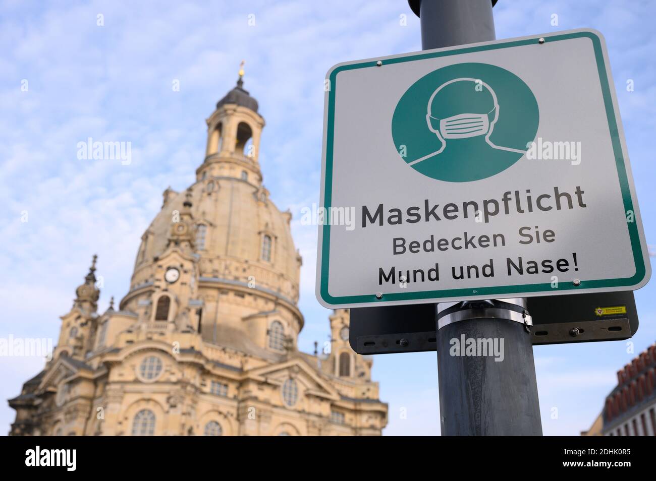 Dresda, Germania. 11 Dicembre 2020. Un cartello che indica che le maschere sono obbligatorie è appeso su un lampione sul Neumarkt di fronte alla Frauenkirche. La Sassonia vuole limitare ulteriormente la vita pubblica in considerazione dei drastici casi di infezione da corona nello Stato libero. Credit: Sebastian Kahnert/dpa-Zentralbild/dpa/Alamy Live News Foto Stock