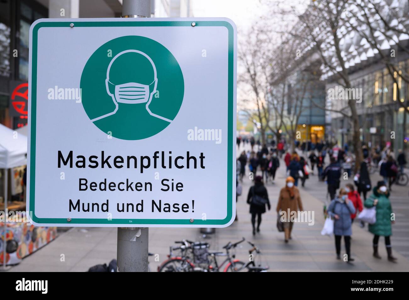 Dresda, Germania. 11 Dicembre 2020. Un cartello che indica che le maschere sono obbligatorie è appeso su un lampione nella via commerciale Prager Straße. La Sassonia vuole limitare ulteriormente la vita pubblica in considerazione dei drastici casi di infezione da corona nello Stato libero. Credit: Sebastian Kahnert/dpa-Zentralbild/dpa/Alamy Live News Foto Stock