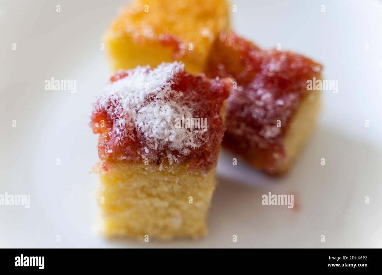 Fetta di torta coperta di confettura di fragole con spolverini di cocco Foto Stock