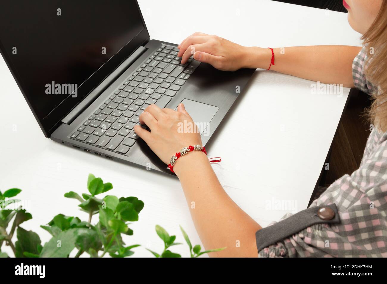 ragazza che scrive il testo sulla tastiera del computer portatile su un tavolo di legno bianco sfondo Foto Stock
