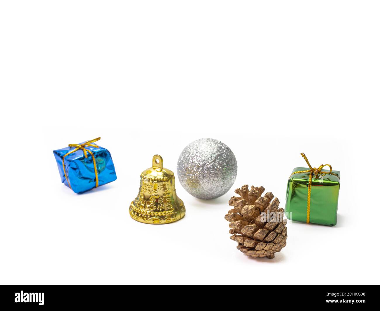 Primo piano di coni di pino natalizio, palle appesi in argento natalizio, campana di jingle dorata, scatole regalo blu e verde per la composizione delle vacanze invernali Foto Stock