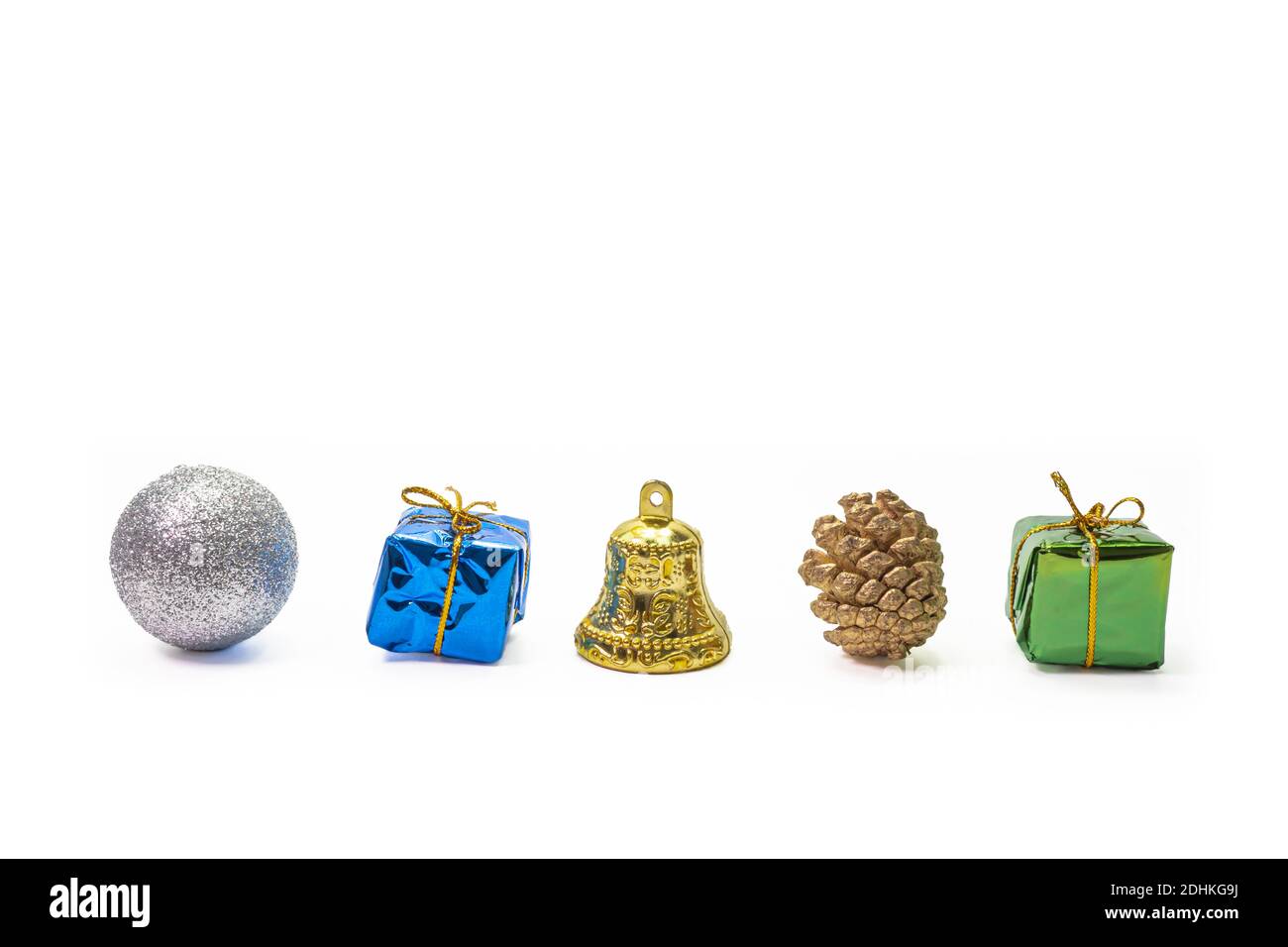 Primo piano di coni di pino natalizio, palle appesi in argento natalizio, campana di jingle dorata, scatole regalo blu e verde per la composizione delle vacanze invernali Foto Stock