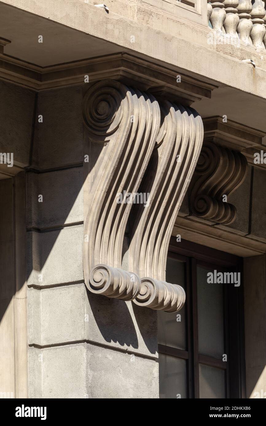 Elementi di decorazioni architettoniche di edifici, una trave sotto il  balcone e una colonna, motivi in gesso e stucco. Per le strade della  Catalogna Foto stock - Alamy