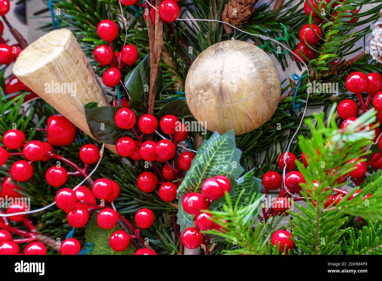 Una palla d'oro, con rami di pino verde, scopa e luci da macellaio,  utilizzata come decorazioni natalizie. Focus centrale Foto stock - Alamy