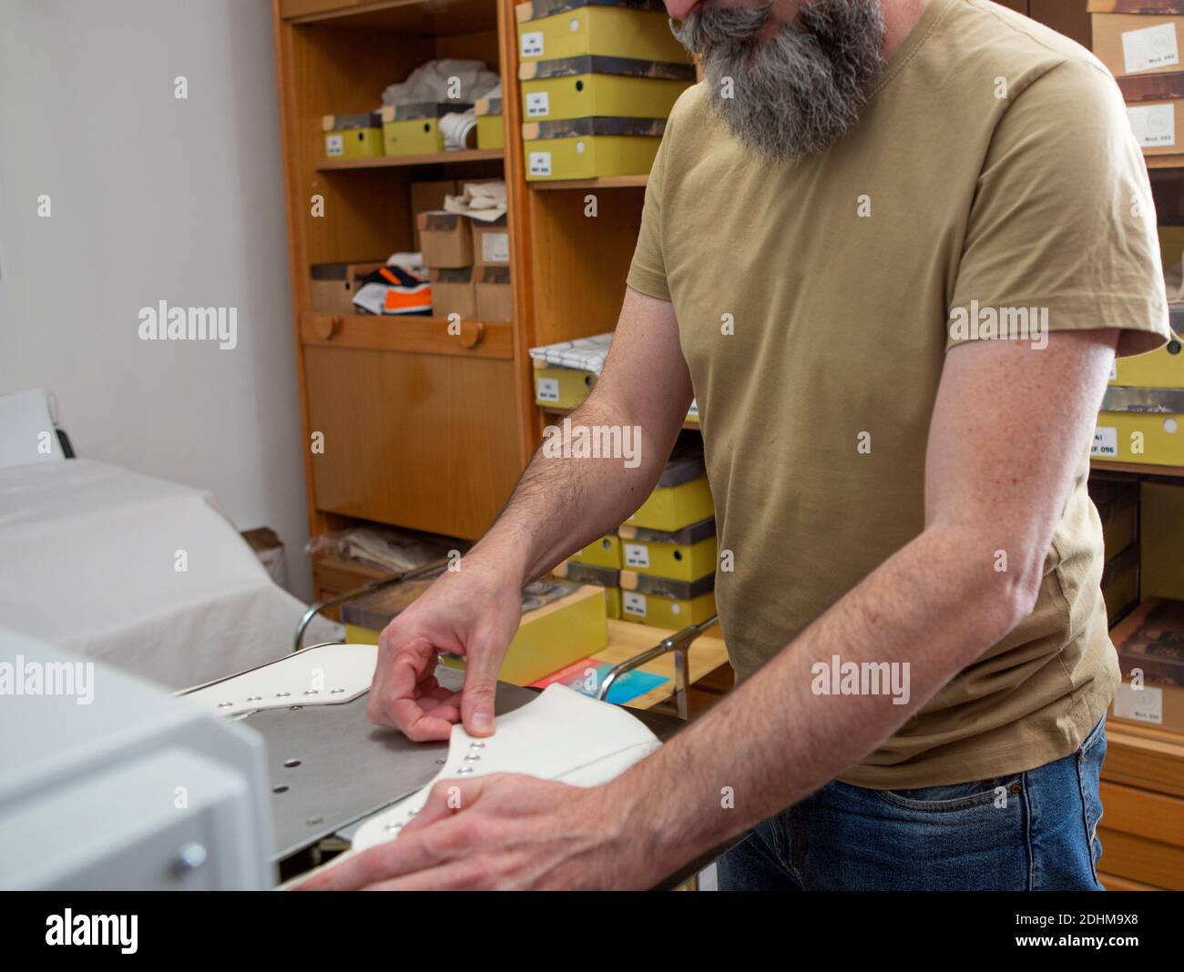 macchina operatrice di stampanti tessili uomo-lavoro per la personalizzazione nello sport scarpe Foto Stock