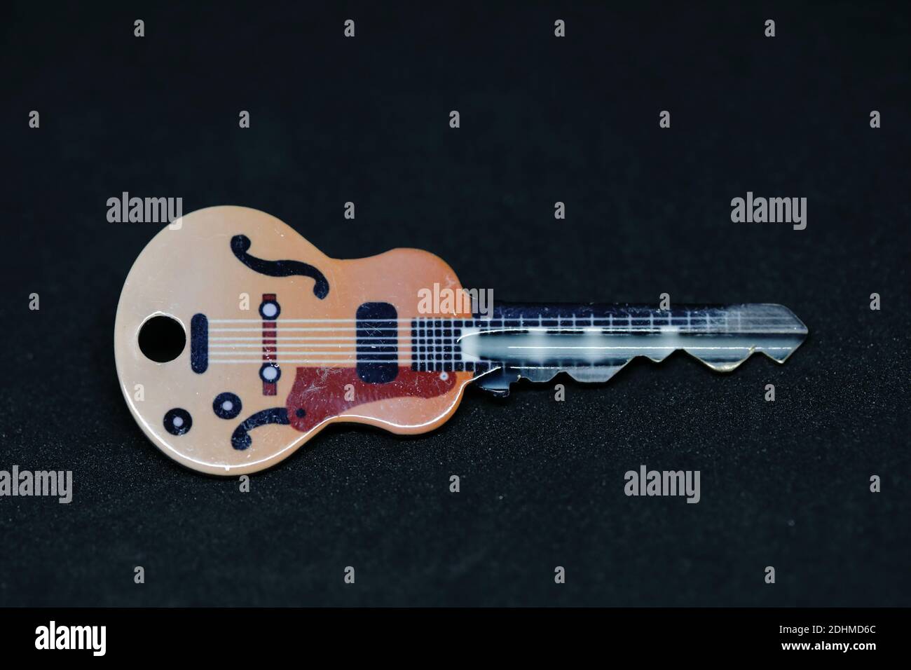 Una chiave della porta fatta apparire come una chitarra uno sfondo nero Foto Stock