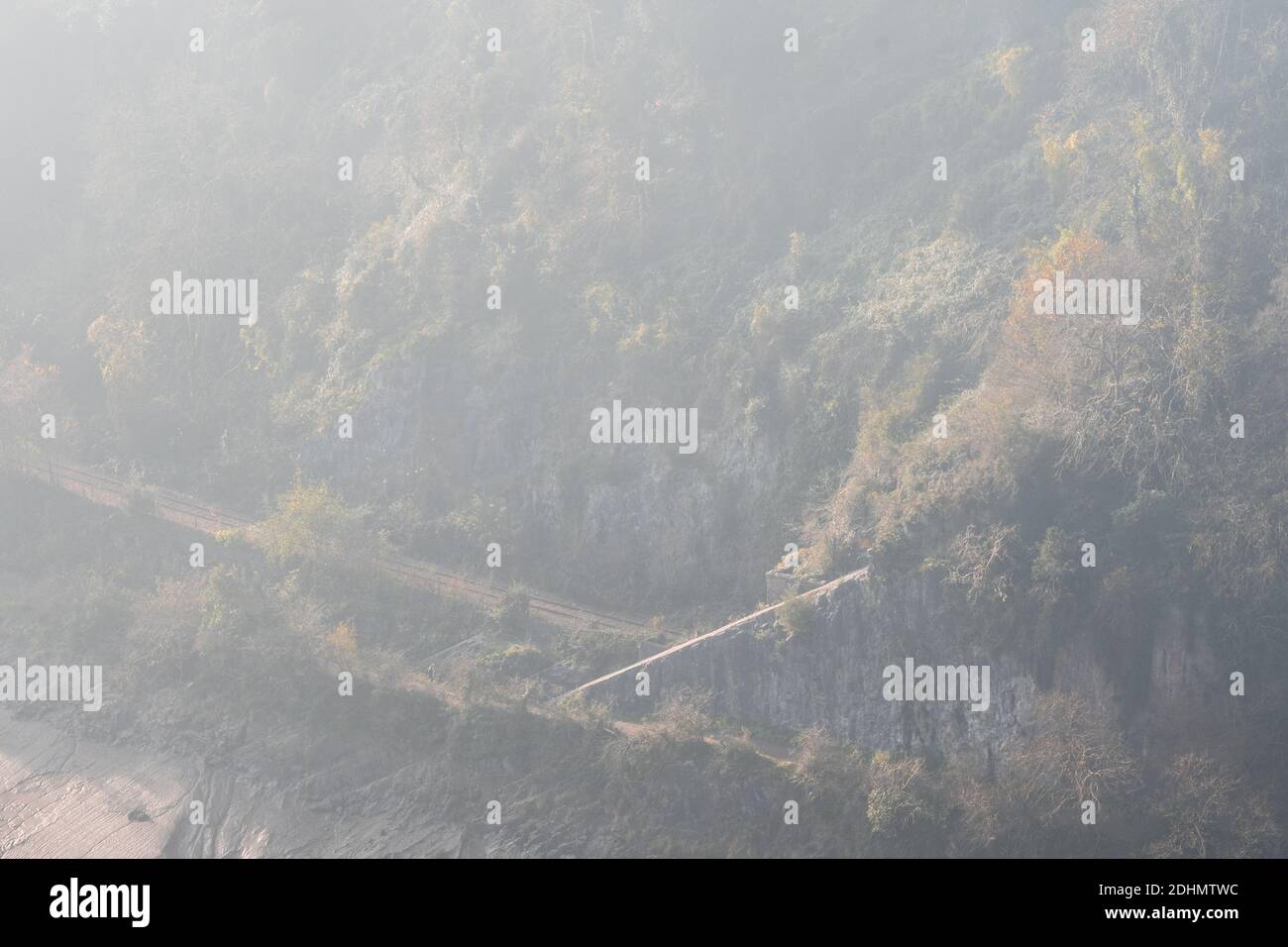 La nebbia sorge dagli alberi di Leigh Woods accanto alla linea di diramazione a singola pista della ferrovia Portishead e al fiume Avon a Bristol. Foto Stock