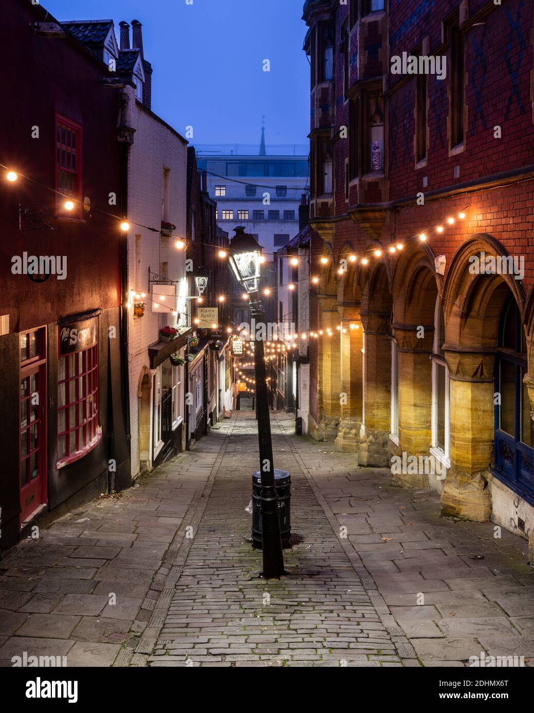 I tradizionali vecchi negozi sono illuminati all'alba sulla pittoresca via dei gradini di Natale di Bristol. Foto Stock