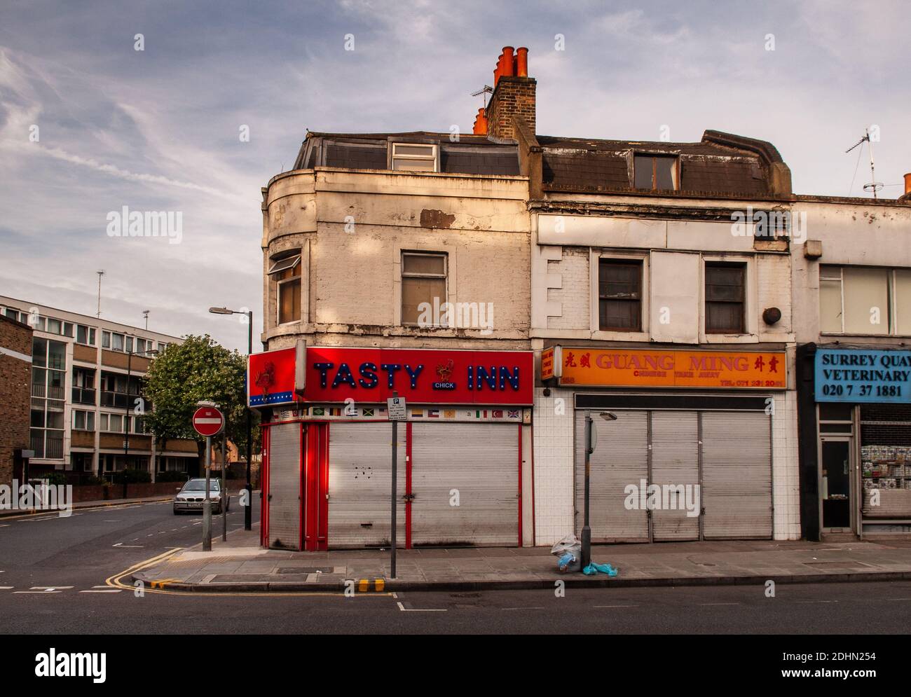 Londra, Inghilterra, Regno Unito - 1 luglio 2010: Il sole di mattina splende sulle case in discesa e take away i ristoranti su Lowe Road nel quartiere di Surrey Quays di S. Foto Stock