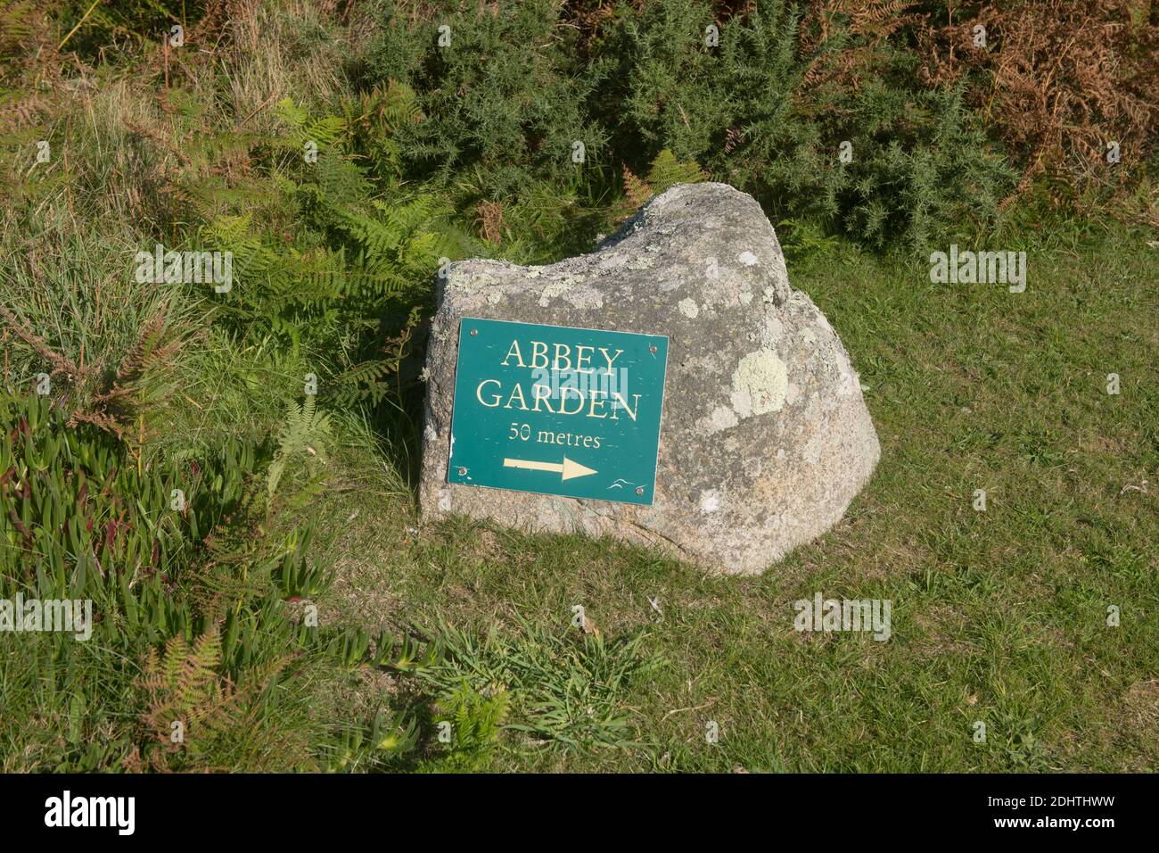 Cartello con le indicazioni per l'Abbey Garden attaccato a Pietra di granito sull'isola di Tresco nelle isole Di Scilly Foto Stock