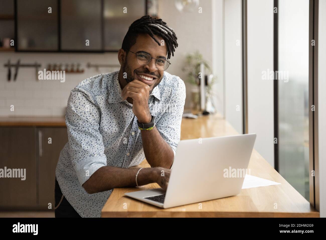 Ritratto di un uomo biraciale sorridente utilizzando un computer portatile Foto Stock