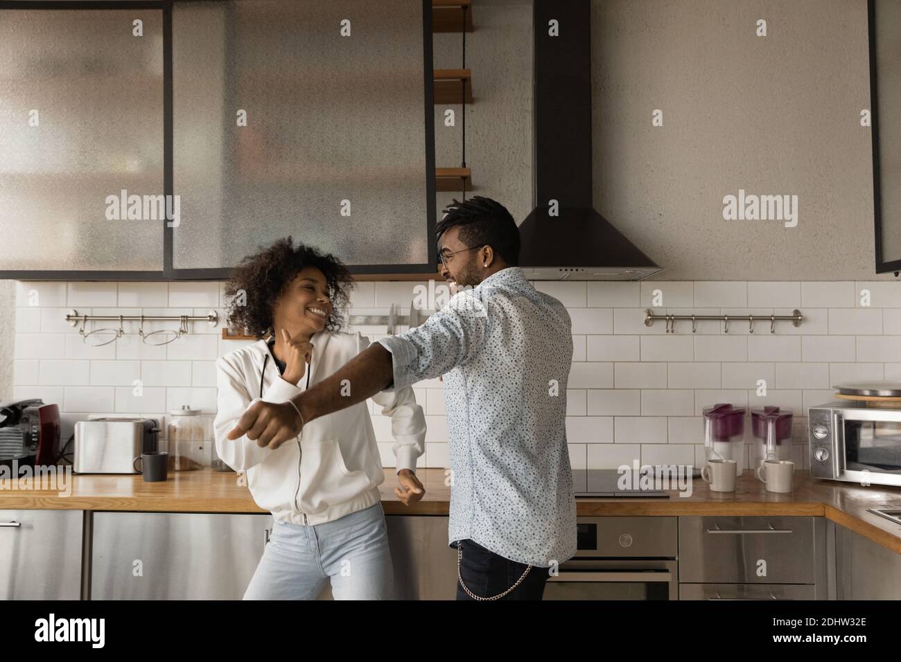 Felice coppia biraciale danza in propria cucina Foto Stock