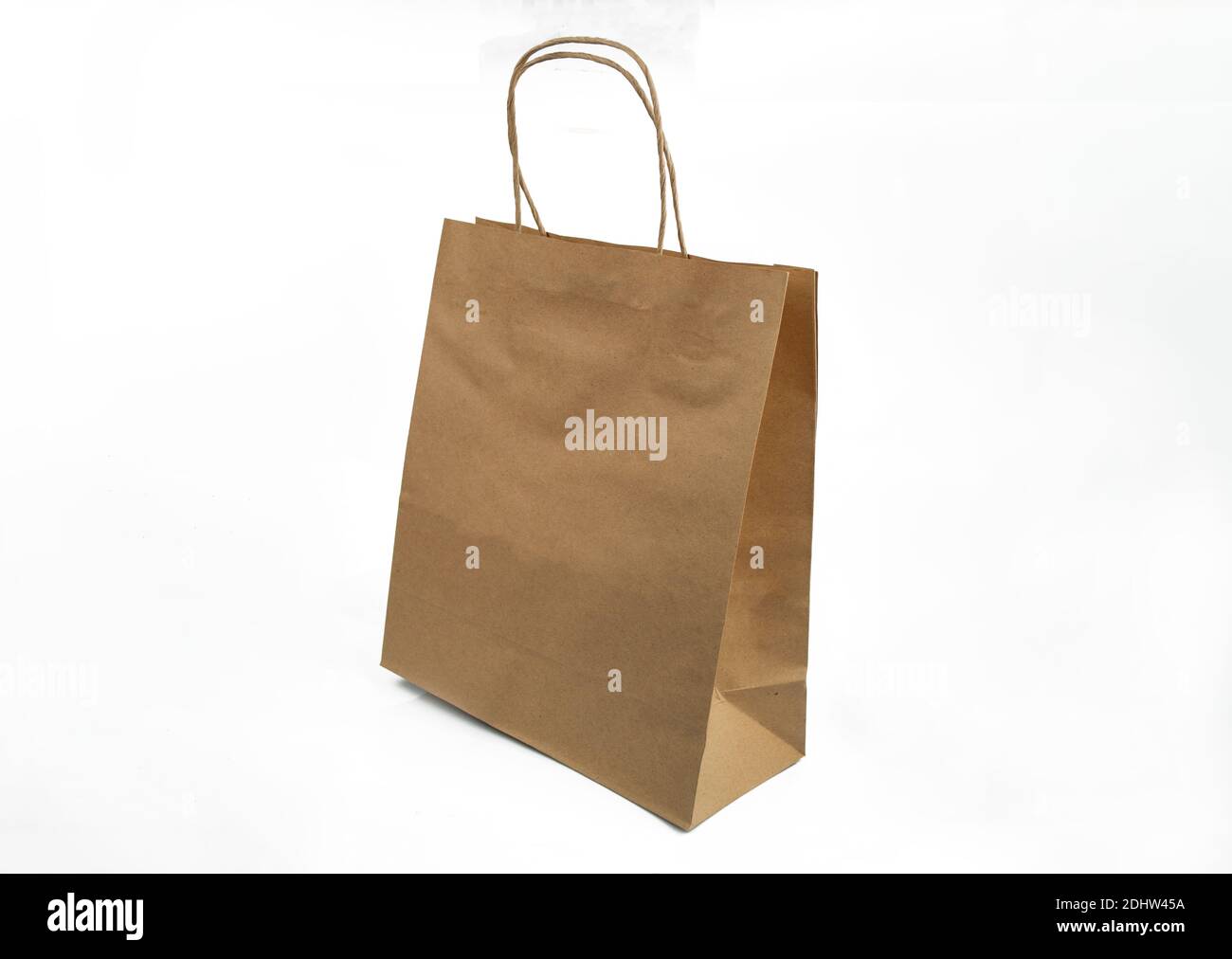 pacchetto ecologico kraft con maniglie per shopping in negozio e consegna su fondo bianco isolato Foto Stock