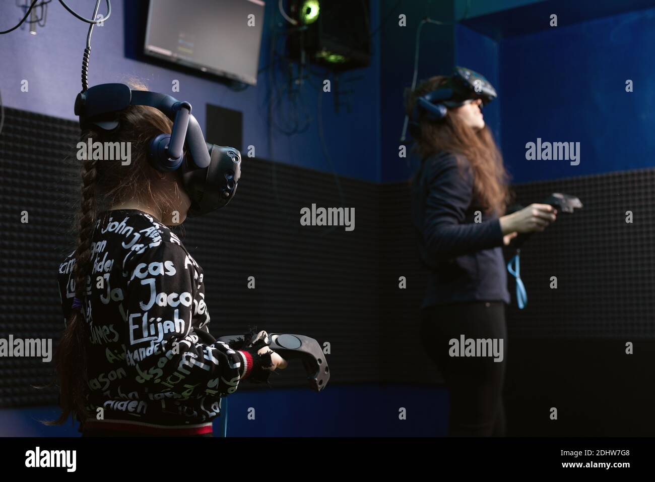 Famiglia che gode della tecnologia VR, figlia e madre nel visore per la realtà virtuale e che gioca ai videogame nel club VR. Tempo libero per la famiglia moderna. Omsk, Russia, Foto Stock