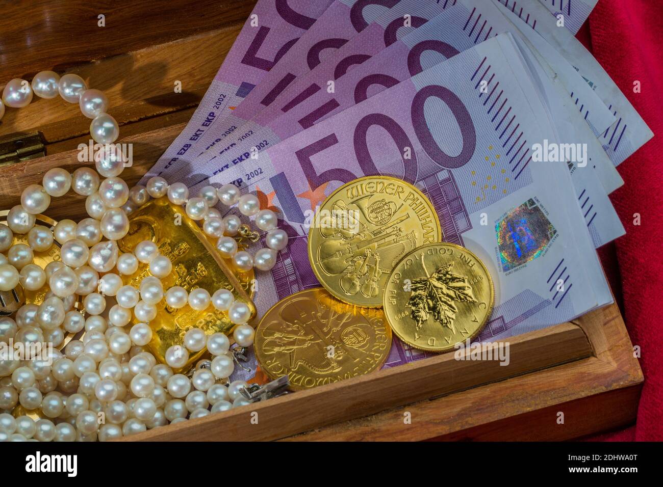 Oro in Münzen und sterile mit Schmuck auf rotem Samt. Symbolfoto für Reichtum, Luxus, Reichensteuer, 500 Euro Scheine, Foto Stock