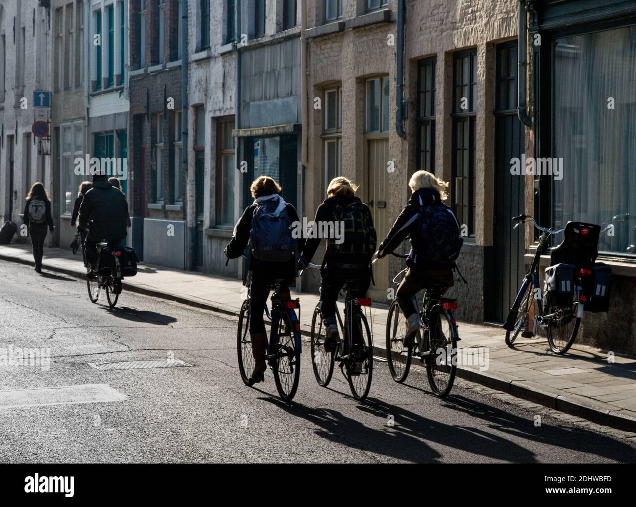 I ciclisti che cavalcano le strade di Bruges in Belgio mattina soleggiata Foto Stock