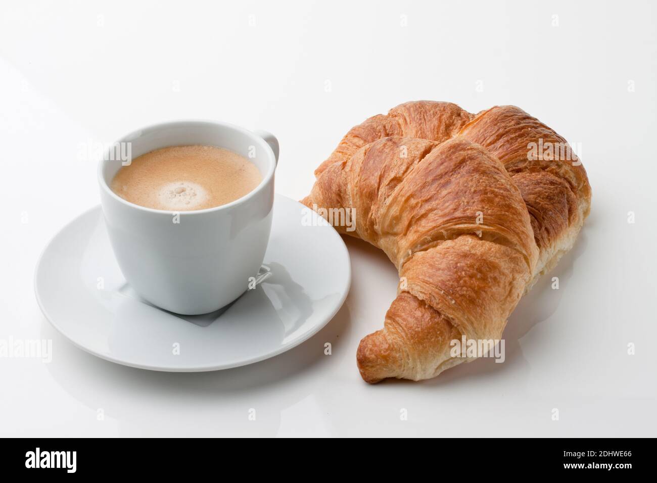 Croissant e eine Tasse Kaffee zum Fruehstueck Foto Stock