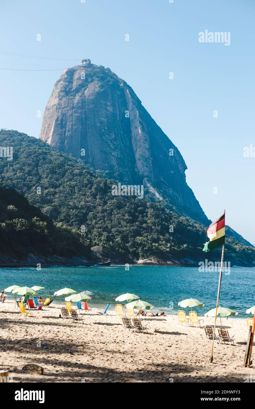 La spiaggia pulita e le acque turchesi di Praia Vermelha a Rio de Janeiro, Brasile, che è retrocesso dal viaggio e punto di riferimento turistico Sugarloaf Mount Foto Stock