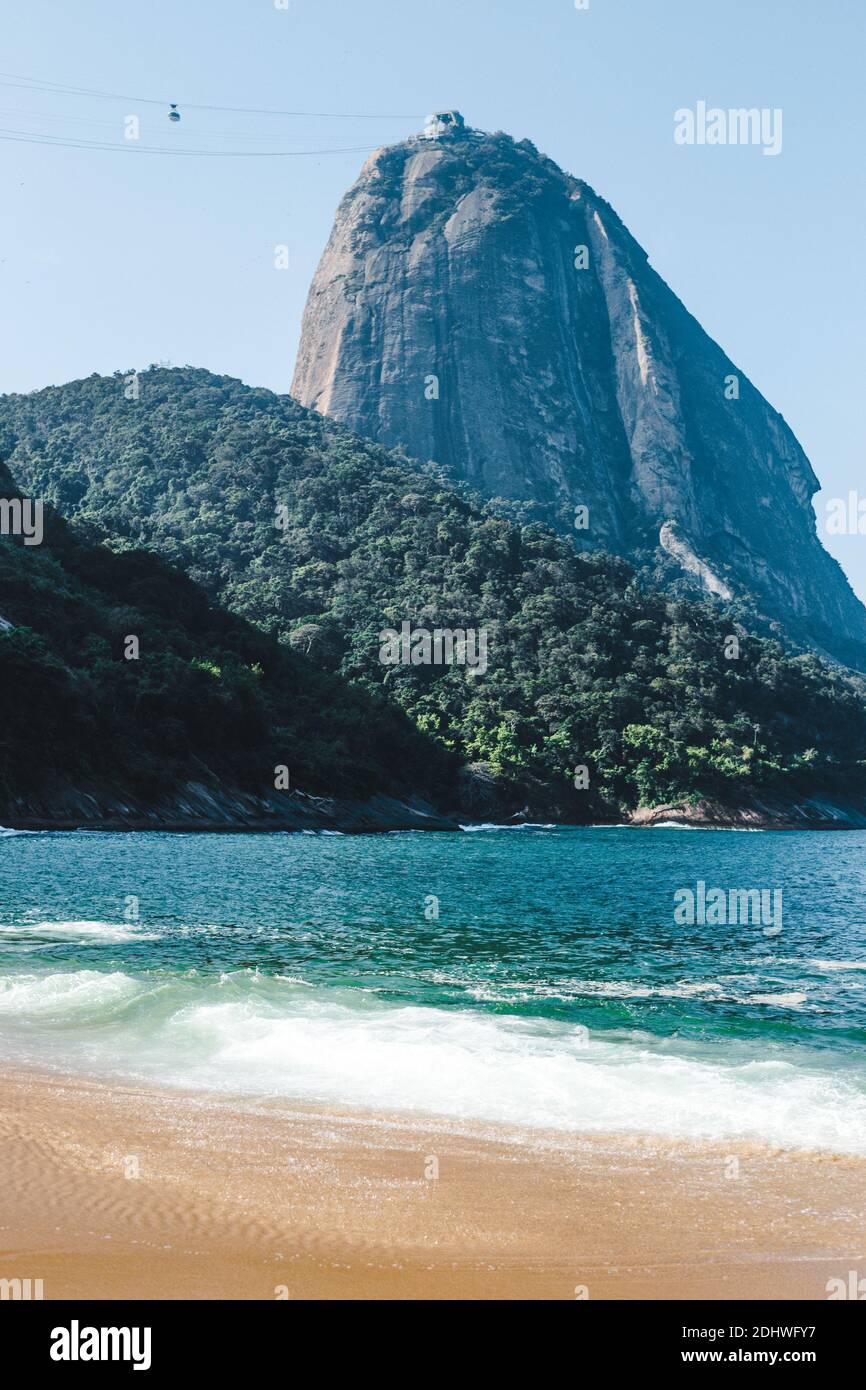 La spiaggia pulita e le acque turchesi di Praia Vermelha a Rio de Janeiro, Brasile, che è retrocesso dal viaggio e punto di riferimento turistico Sugarloaf Mount Foto Stock