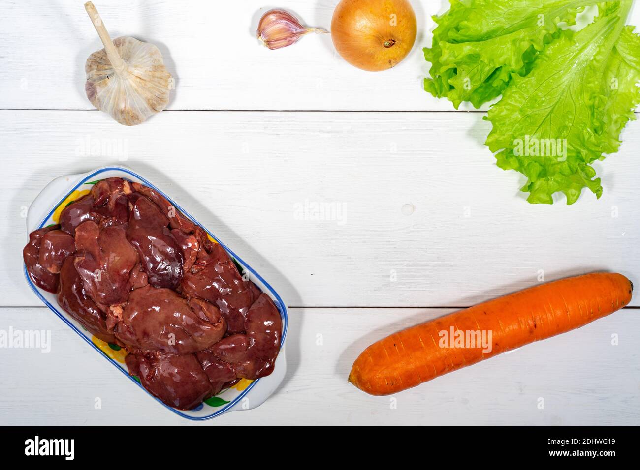 fegato di pollo e verdure su sfondo ligneo. set di cibi crudi per cucinare. spazio per testo e spazio per la copia Foto Stock