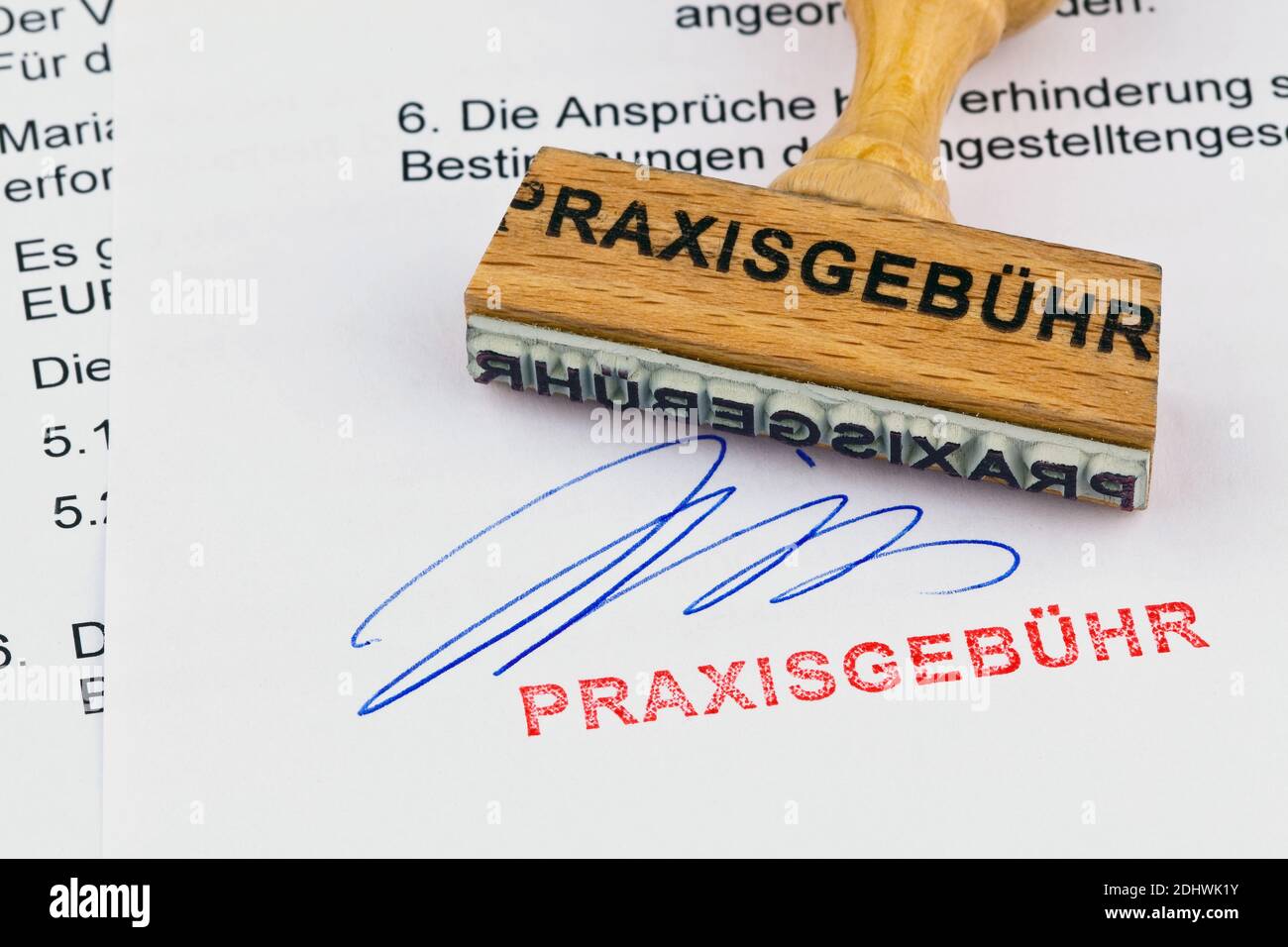 Ein Stempel aus Holz liegt auf einem Dokument. Aufschrift Praxisgebühr Foto Stock