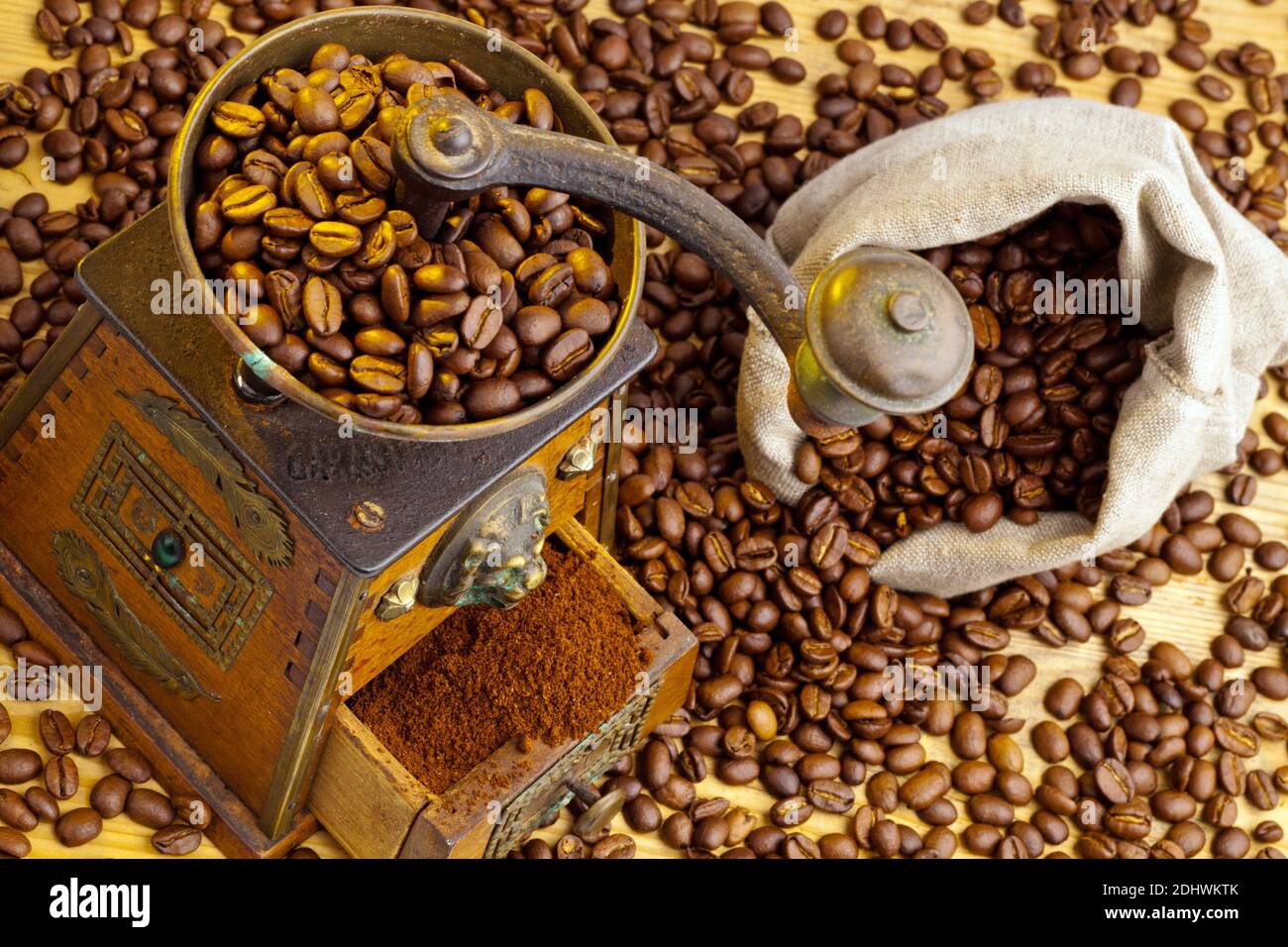 Kaffeebohnen liegen neben einer Kaffeemühle. Frisch gemahlener Kaffee. Foto Stock