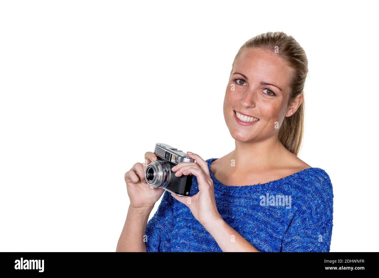 Eine junge Frau mit einem alten Fotoapparat. Kameras im retro Look sind wieder in. Foto Stock