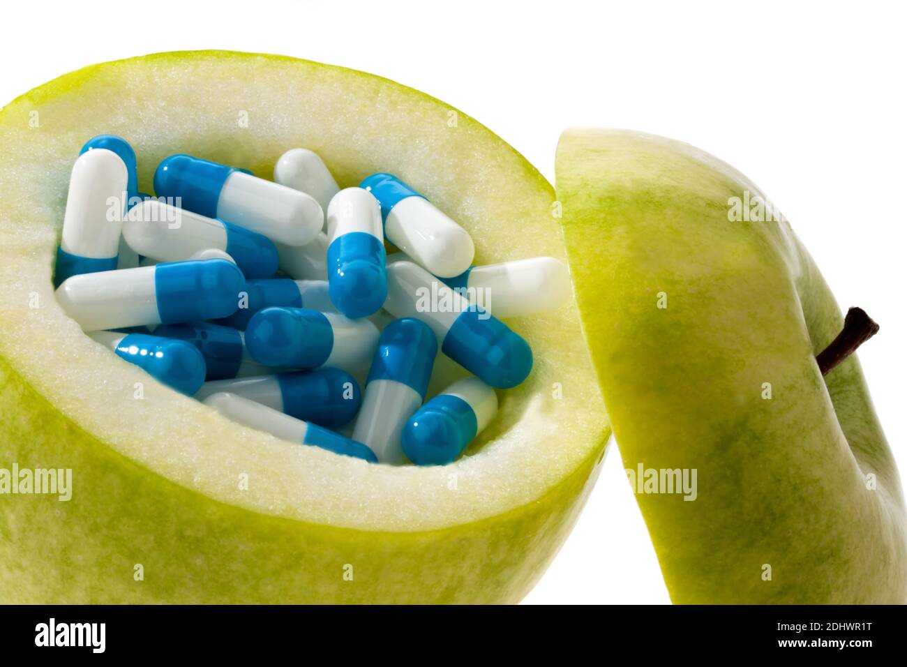 Grüner Apfel mit Diätpillen. Symbolfoto für Abnehmen. Foto Stock