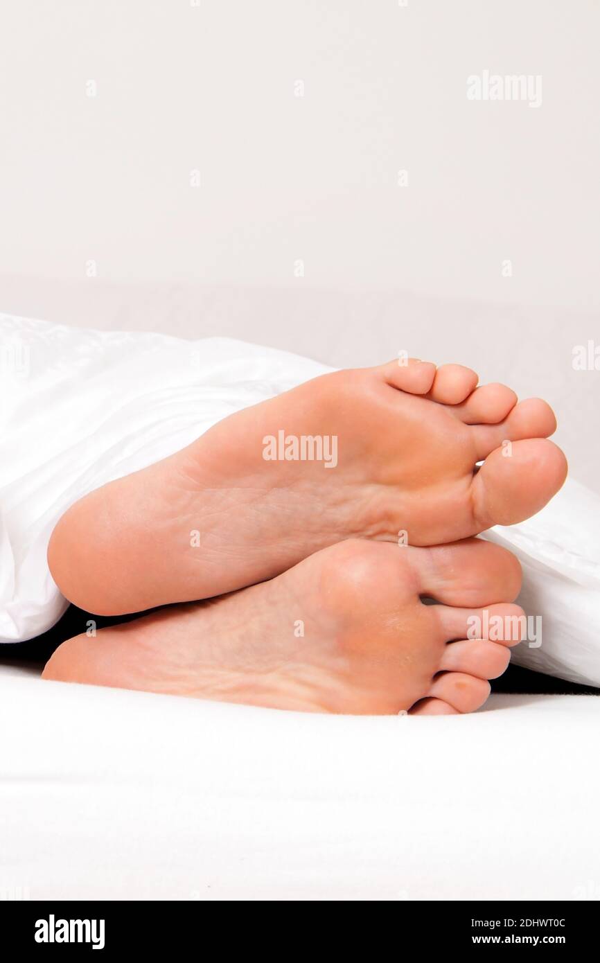 Dier Füße einer Frau im Bett. Foto Stock