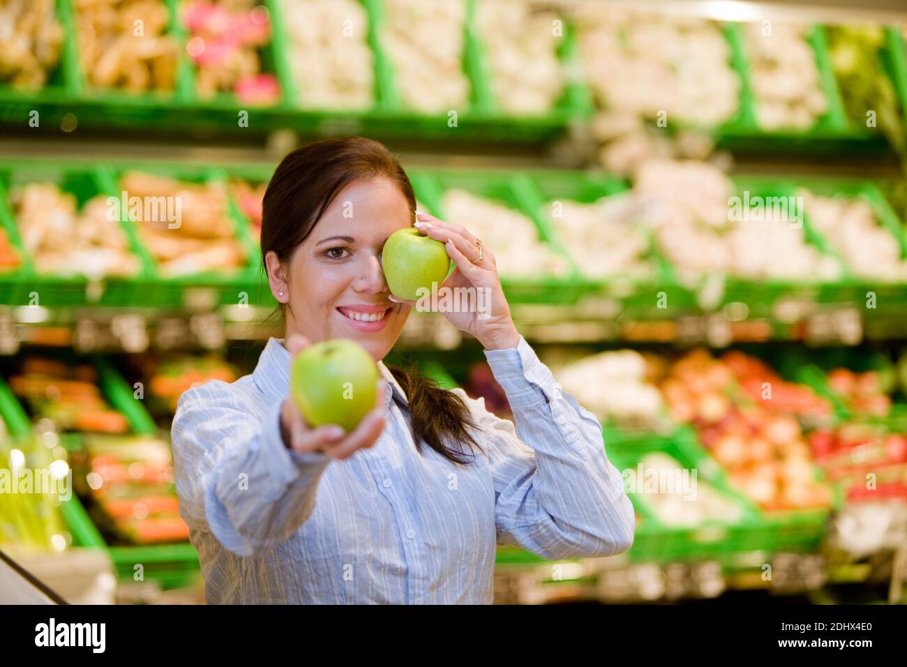 Junge Frau kauft im Supermarkt Lebensmittel und Obst ein, MR: Sì Foto Stock