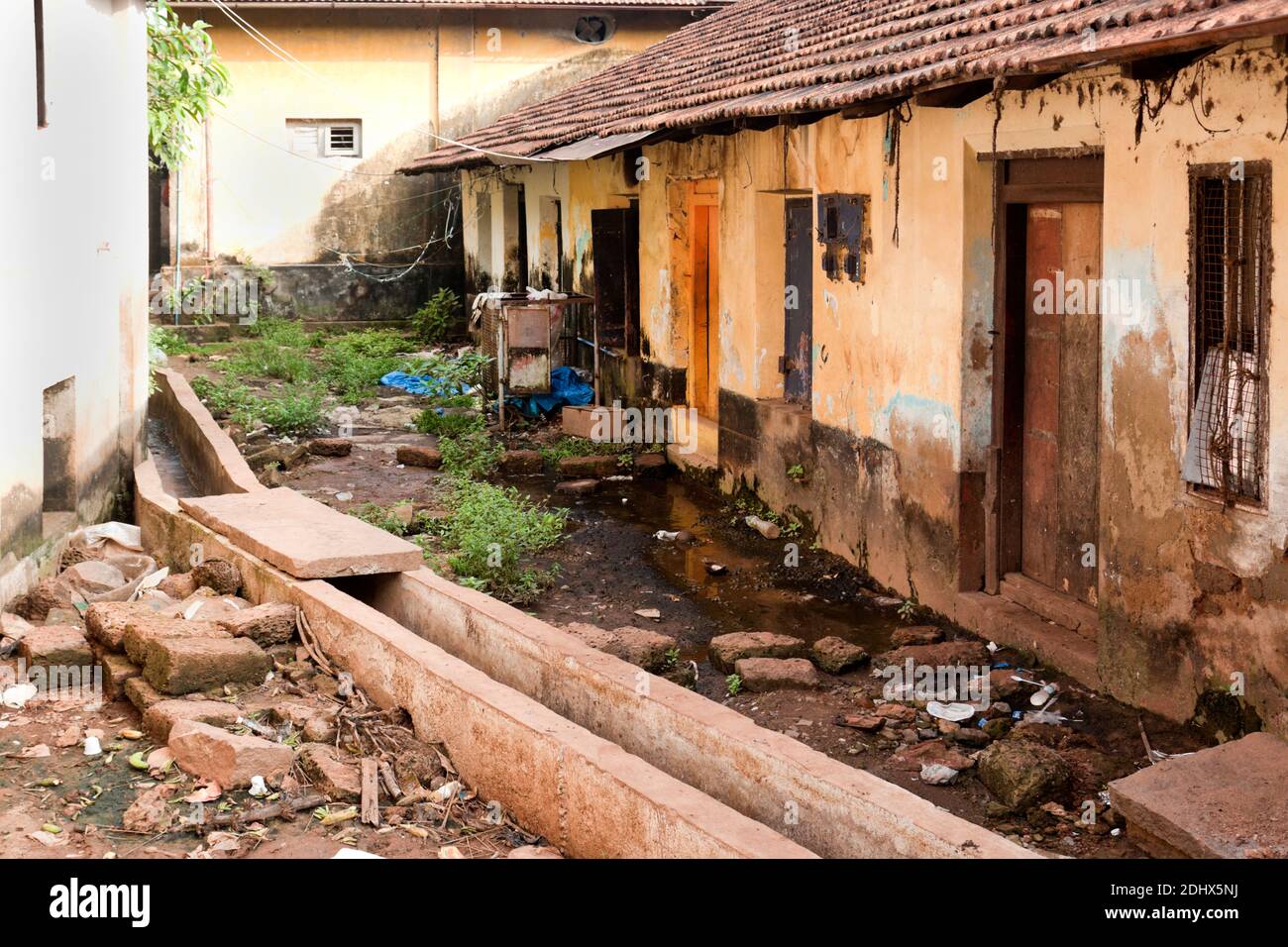 Back Street slums, Mangalore India - open drain e scendono case. La privazione e la povertà sono chiare Foto Stock
