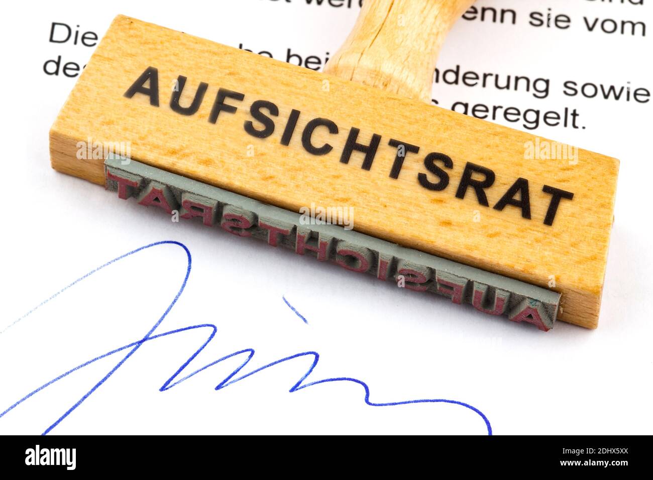 Ein Stempel aus Holz liegt auf einem Dokument. Deutsche Aufschrift: Aufsichtsrat Foto Stock